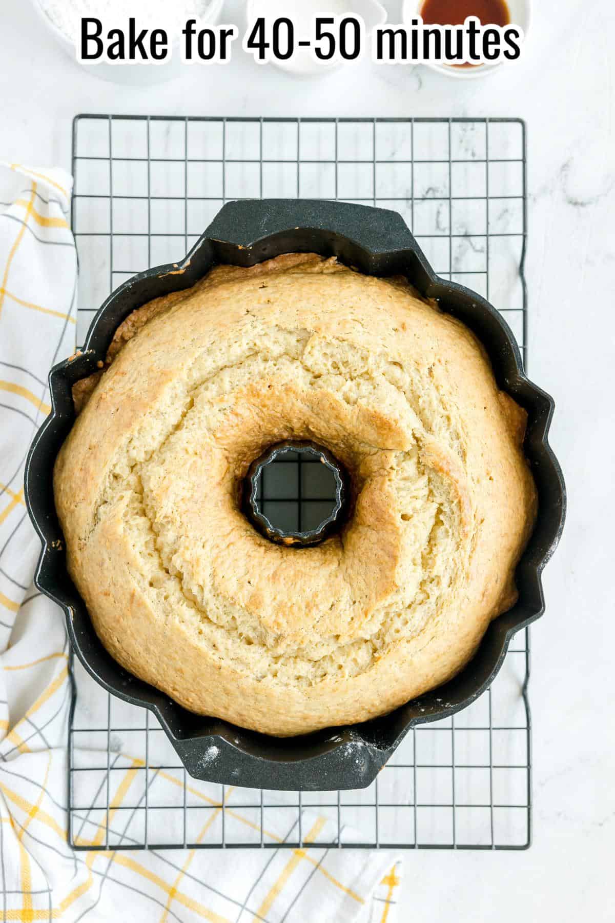 A baked bundt cake in a pan cooling on a wire rack, with text above that says, "Bake for 40-50 minutes.