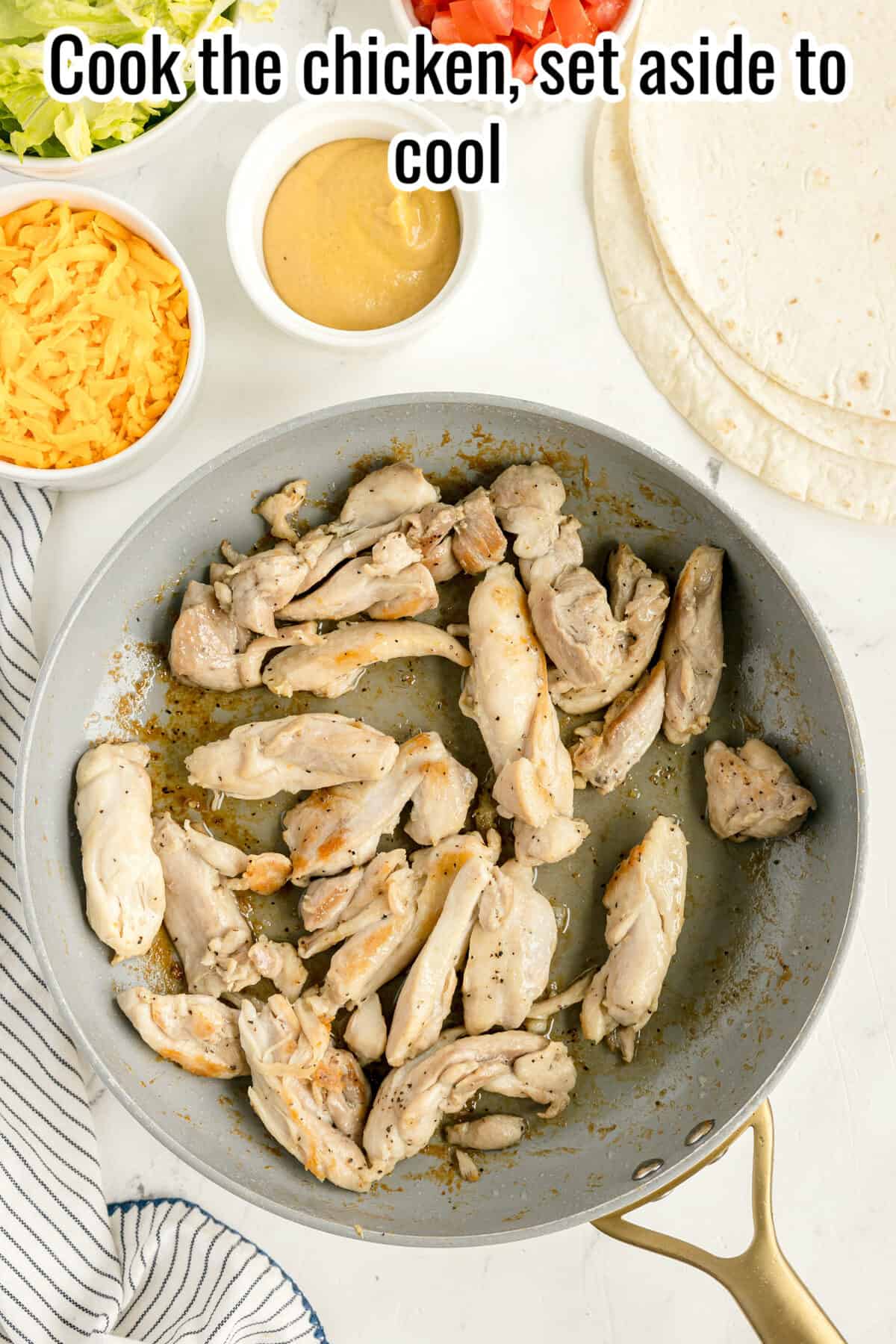 Cooked chicken pieces in a frying pan on a white surface, with shredded cheese, sauce, and tortillas nearby; text reads, “Cook the chicken, set aside to cool.”.