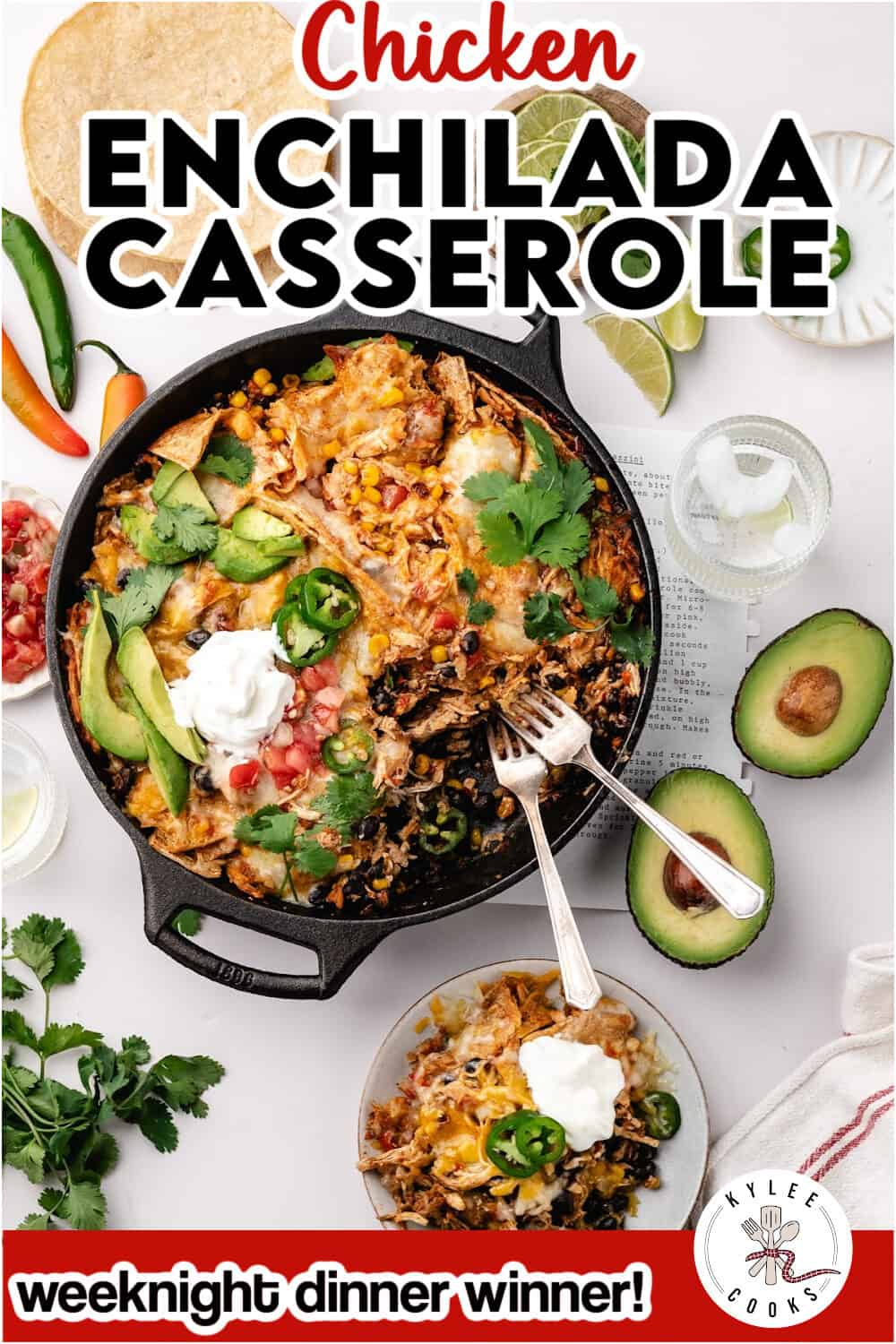 Chicken enchilada casserole in a cast iron skillet, topped with avocado, sour cream, and jalapeños, with a serving on a small plate.