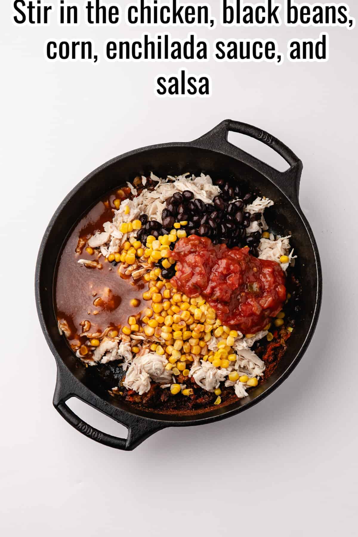 A black cast-iron skillet containing shredded chicken, black beans, corn, and red salsa, with text above reading “Stir in the chicken, black beans, corn, enchilada sauce, and salsa.”